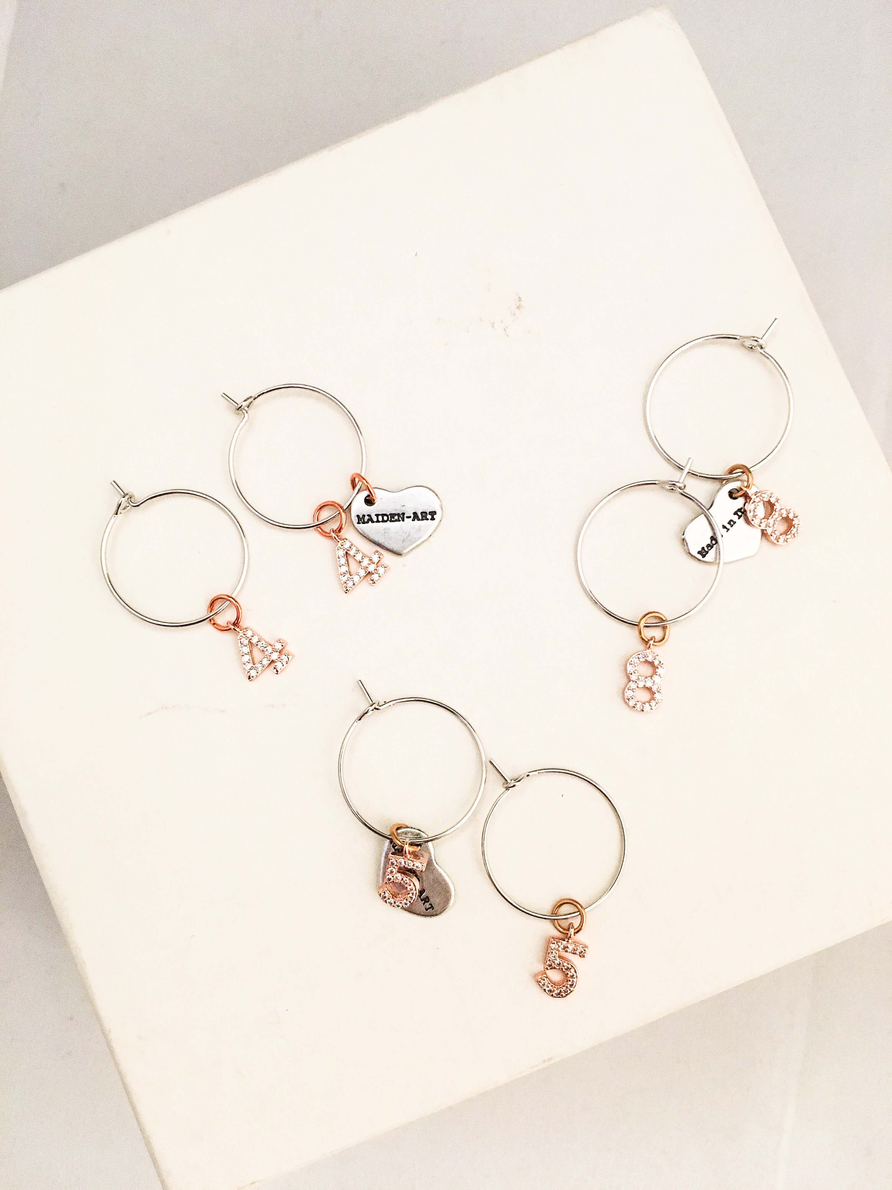 Number hoop earrings in silver, rose gold and rhinestones.